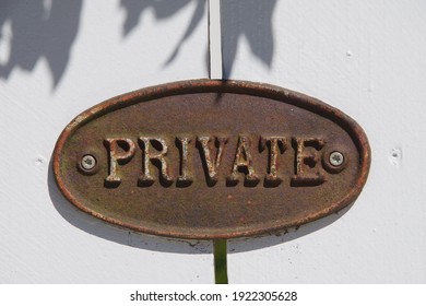 Close-up View Of An Oval Metal Sign On A White Painted Wooden Structure