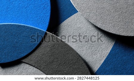 Close-up view of overlapping circular shapes with textured surfaces in shades of blue and gray, creating an abstract pattern.