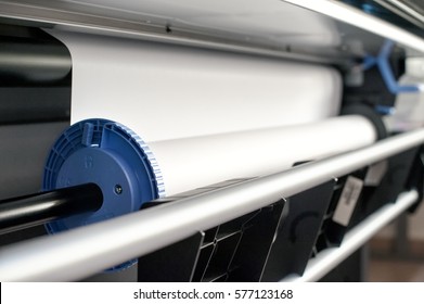 Close-up view of paper roll mechanism of professional wide format printer with white paper loaded inside