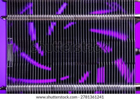 Close-up view of parallel metallic coils arranged with thin vertical wires creating a geometric pattern. Purple light softly illuminates the background, highlighting the industrial texture and reflect