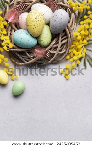 A close-up view of pastel-colored Easter eggs in a small basket, decorated with yellow spring flowers, symbolizing Easter celebration.