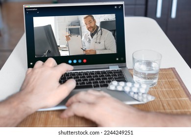 A close-up view of a patient's hand in front of a laptop during an online consultation with a doctor. - Shutterstock ID 2244249251