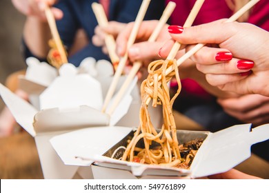 Close-up View Of People Eating Noodles With Chopsticks 