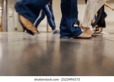 A close-up view of people walking in a corridor of a train station's terminal building highlights various types of fashion. The low angle view additionally reflects movement in a busy environment. - Powered by Shutterstock