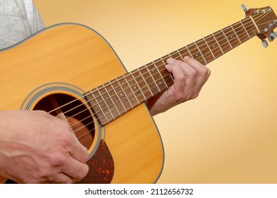 Closeup view of a person playing an acoustic guitar 