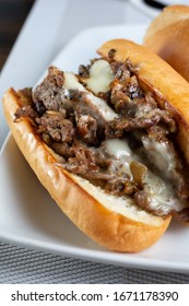 A closeup view of a philly cheesesteak sandwich, in a restaurant or kitchen setting.