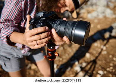 Close-up view of a photographer adjusting a camera on a tripod outdoors. Capturing a perfect shot in natural light, showcasing the art and skill of photography. - Powered by Shutterstock