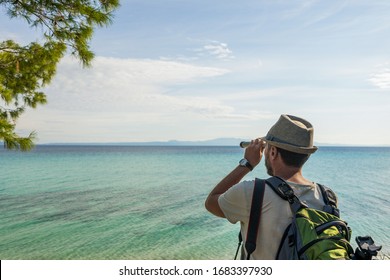 Closeup View Photography Of Male Tourist Looking Through Old Vintage Telescope Far Away In Distance At Beautiful Seascape Of Aegean Sea In Greece Landscape.