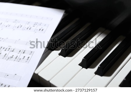 Closeup view of piano keys with notes. Musical instrument