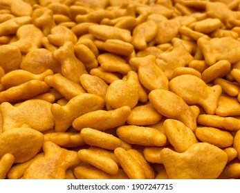 Close-up View Pile Of Cheese Flavored Fish Shaped Cracker Treats Snacks On Table