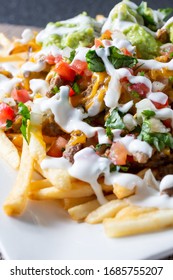 A Closeup View Of A Plate Of Carne Asada Fries, In A Restaurant Or Kitchen Setting.