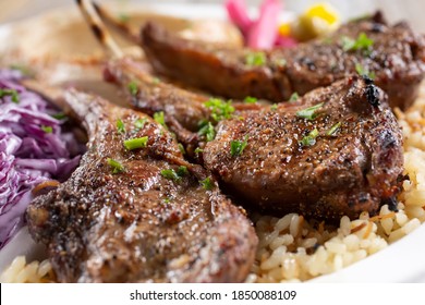 A Closeup View Of A Plate Of Grilled Lamb Chops.