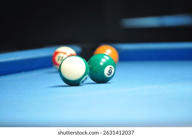  a close-up view of a pool table with several billiard balls, including the 9-ball, resting on the vibrant blue felt, creating a dynamic and visually engaging composition.