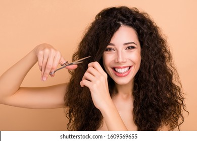 Close-up View Portrait Of Her She Nice-looking Charming Cute Winsome Attractive Lovely Cheerful Cheery Wavy-haired Girl Cutting Tight Curls With Sharp Scissors Isolated On Beige Background