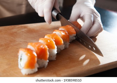 Close-up view of process of preparing rolling sushi. making the sushi with sauce and sesame seeds, pours delicious fresh rolls with a sauce. Dark background - Powered by Shutterstock