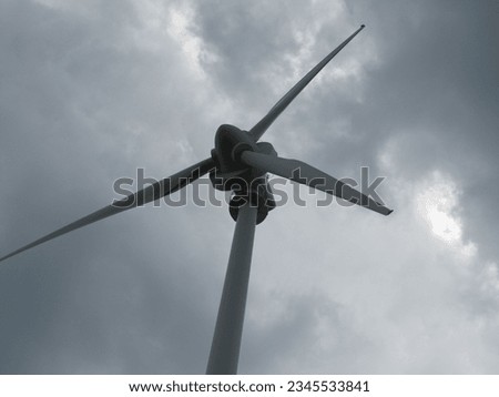 A close-up view of the propellers of the wind generator during the production of electric power. In the background you can see the sky partially obscured by dark clouds