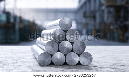 A close-up view of a pyramid stack of shiny metal rods, likely aluminum or steel, in an industrial environment.