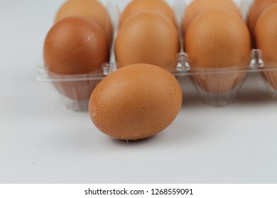 Close-up view of raw chicken eggs in egg box on white white background - Shutterstock ID 1268559091