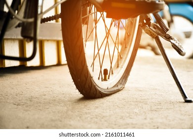 Closeup view of rear flat tire of vintage bicycle which parked on pavement beside the road. soft and selective focus.