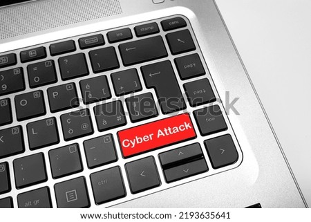 Close-up view of red button on white keyboard with text "cyber attack". Computer hacking concept.