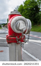 closeup view of a red fire hydrant beside a roadway and pedestrian crossing. urban emergency infrastructure providing rapid water access for firefighting, rescue services and public safety operations.