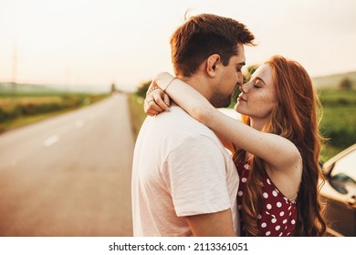 Close-up view of a red-haired girl in love embracing her boyfriend enjoying the moment with her eyes closed, standing on the side of the road before embarking - Shutterstock ID 2113361051
