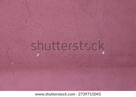 a closeup view of a redpainted wall with cracks and peeling paint visible on the surface