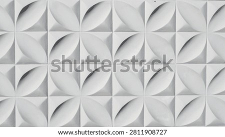 A close-up view of a repeating geometric pattern of white concave petal-shaped forms on a square grid background, featuring natural lighting and