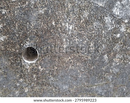 Close-up view of a retaining wall featuring a PVC drainage pipe (weep hole) designed to release trapped groundwater and reduce hydrostatic pressure behind the structure. This essential civil engineering component helps prevent wall cracking, soil failure, structural instability, and landslides. The image highlights drainage infrastructure, geotechnical engineering, retaining wall construction, and water management systems in modern civil works.