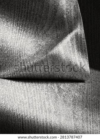 A closeup view reveals a surface covered in intricate frost crystals, dramatically highlighted by sharp diagonal and horizontal shadows