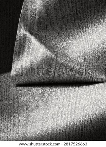 A closeup view reveals a surface covered in intricate frost crystals, dramatically highlighted by sharp diagonal and horizontal shadows