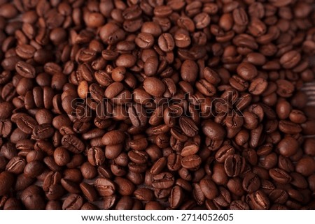 close-up view of a rich, textured array of roasted coffee beans displaying a warm, earthy palette and intricate details in a cozy and inviting atmosphere, energizing, darkbrown, shiny, colorful