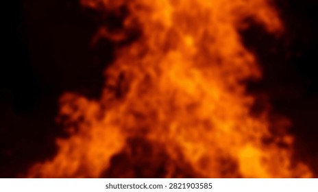 A close-up view of a roaring bonfire with dynamic flames in shades of orange and yellow, set against a deep black night sky.