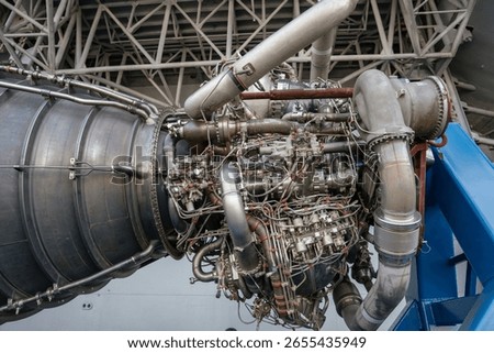 A close-up view of the rocket engine showing a dense network of wiring, valves, and mechanical components. This high-performance engine is used in space missions.