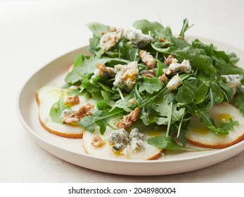 close-up view of rocket salad dish with pear, blue cheese and walnuts