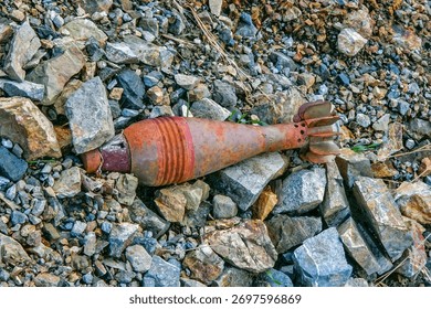 A close-up view of a rusted mortar shell or similar unexploded ordnance