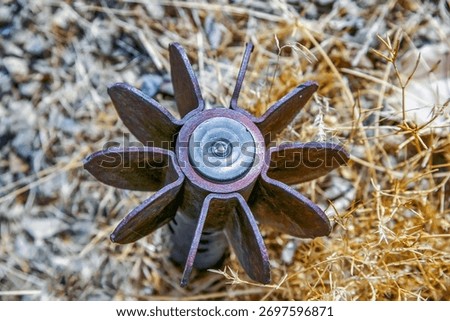 A close-up view of a rusted mortar shell or similar unexploded ordnance