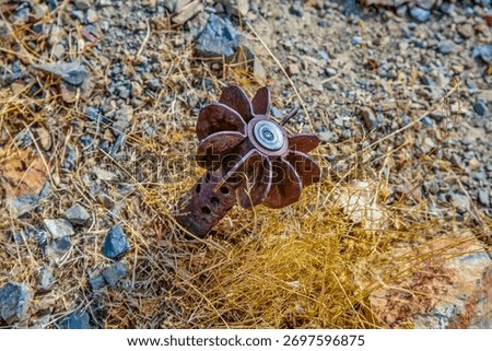 A close-up view of a rusted mortar shell or similar unexploded ordnance