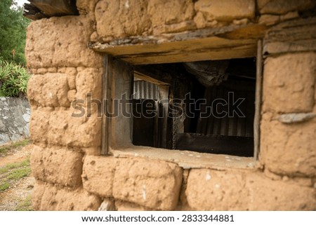 Close-up view of a rustic adobe wall window in a traditional rur