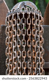 A close-up view of rusty chains hanging from a metal structure, showcasing the texture and patina of aged metal. Chains are arranged in a vertical pattern, with the rust creating a richcolor palette. 