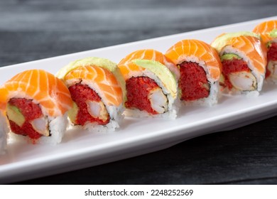 A closeup view of a salmon, ahi tuna, avocado sushi roll, featuring tempura shrimp. - Shutterstock ID 2248252569