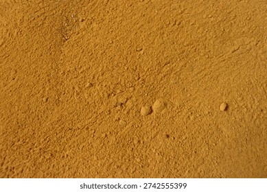 A close-up view of a sandy surface with small bumps and imperfections.