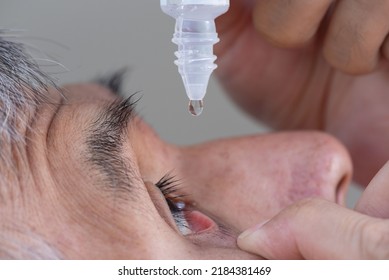 Close-up view of a senior Asian adult male using eye drop in right eye after catarct surgery. - Shutterstock ID 2184381469