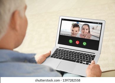 Closeup View Of Senior Man Talking With Grandchildren Via Video Chat At Home 