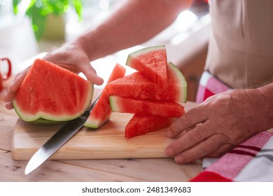 Close-up view of senior people's hands cutting a red juicy watermelon in slices, healthy and refreshing snack - Powered by Shutterstock