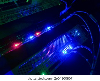 A close-up view of a server rack showcasing vibrant LED lights in blue and red. The image highlights the intricate details of wires and connections within a modern data center. - Powered by Shutterstock - Get 15% off with code: PIKWIZARD15