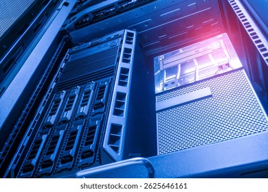 A close-up view of a server rack showcasing multiple storage units and advanced technology, illuminated by soft blue lighting in a secure environment.