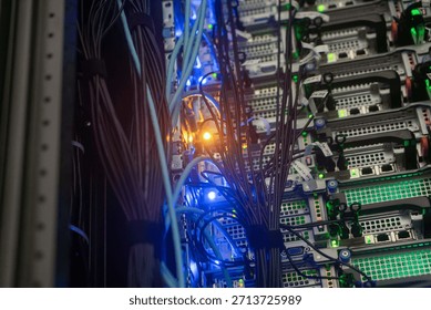 Close-up view of a server rack showcasing wires and illuminated LED lights. The image captures the intricate layout of electronic devices and connections.