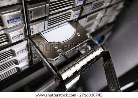 A close-up view of a server storage system showcasing a hard drive removal tool. This high-tech setup emphasizes the importance of data management and retrieval processes in modern computing environments.