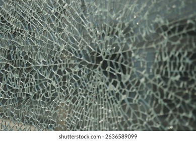 Close-up view of a shattered glass pane, showcasing a complex network of cracks radiating from a central point. The texture is detailed, showing the fragmented pieces. - Powered by Shutterstock - Get 15% off with code: PIKWIZARD15